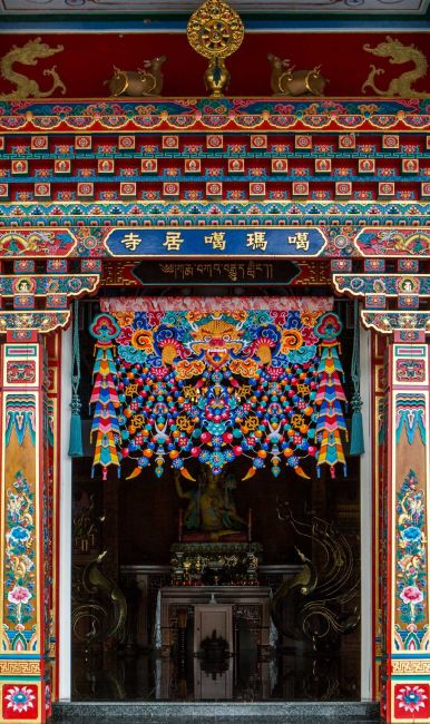雀替是藏式樑柱名稱，西藏傳承印度建築風格，表現在柱子上美學，柱底雀替向兩旁木面作鏤空狀延伸，具力學支撐功能，且兼具裝飾作用。中央梵文種子字裝嚴，提名噶瑪噶居寺，柱子四面蟠龍掌八吉祥，是台檜雕刻彩繪，雕工精細。門簾以札哇札切裝嚴，是一塌鼻獸吐出半滿瓔珞與七政八寶和飄帶串成華麗花鬘，為藏族特殊的藝術，值得仔細觀賞。